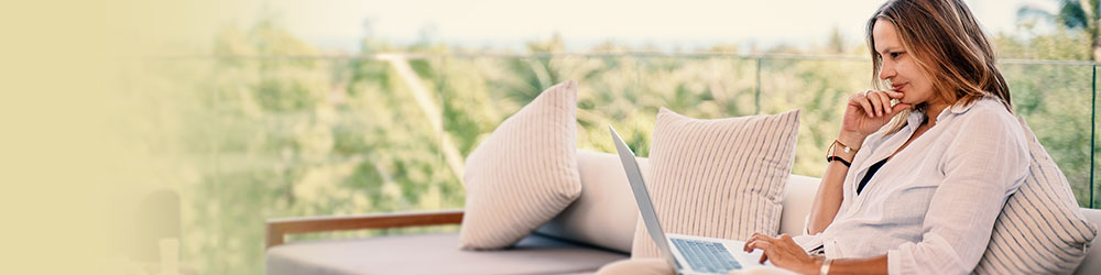 woman sitting on couch looking at laptop